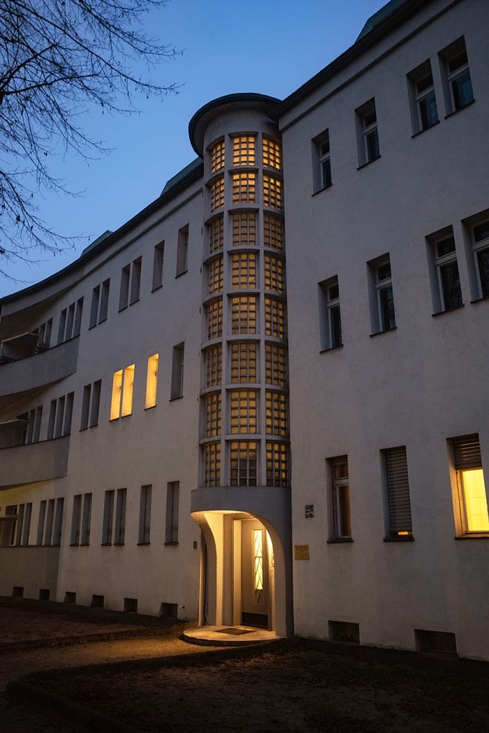 The snow-white facade with curved balconies and rounded staircases.