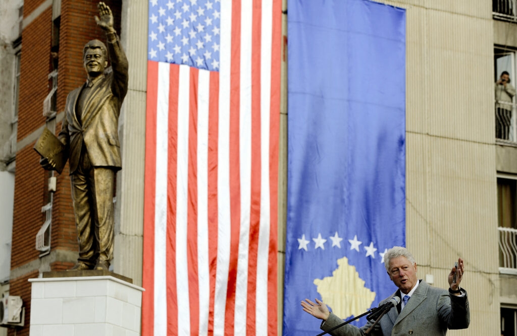 Колишній президент США Білл Клінтон виступає з промовою перед його статуєю під час свого візиту до Приштини у 2009 році | Арменд Німані/AFP через Getty Images