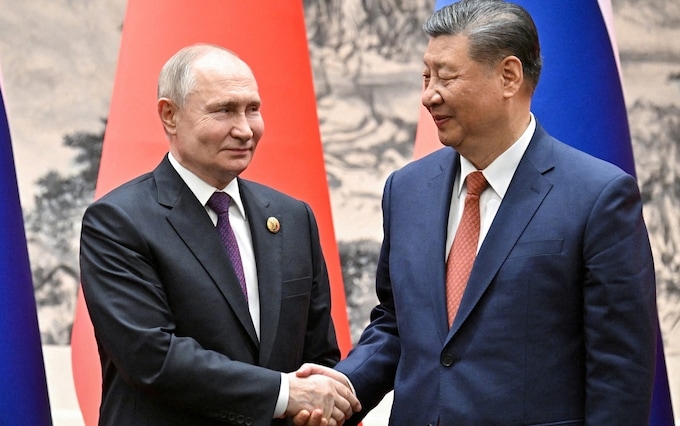 Russian President Vladimir Putin shakes hands with Chinese President Xi Jinping during a meeting in Beijing