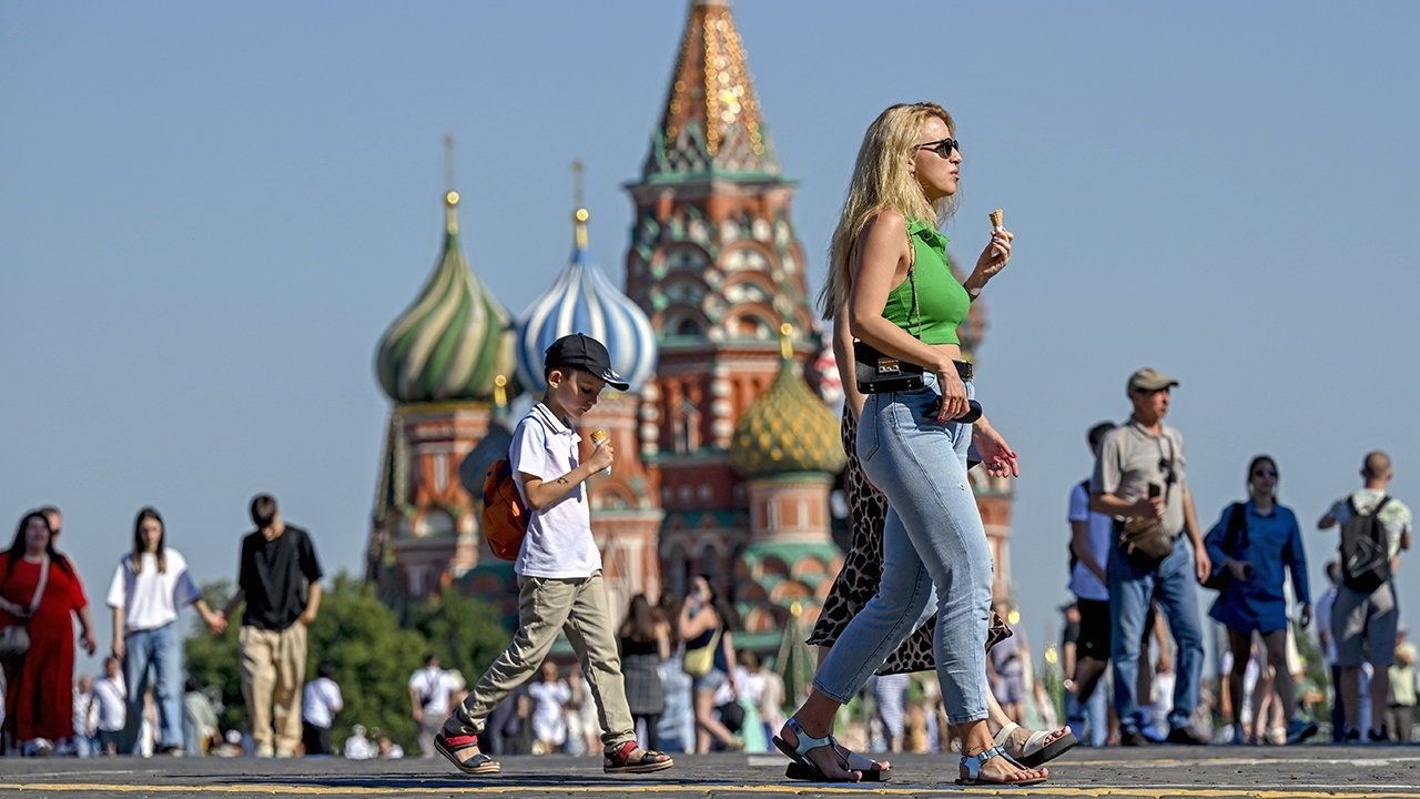 Some citizens take walks around the historic Red Square.