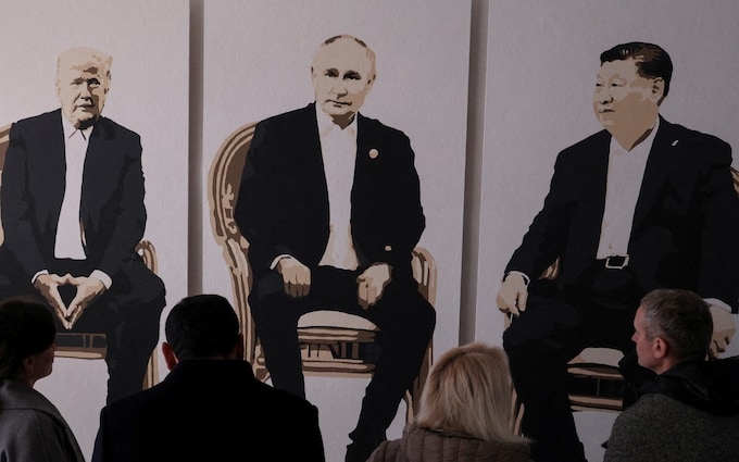 Visitors stand in front of an artwork depicting Donald Trump, Vladimir Putin and Xi Jinping at an exhibition in Yalta