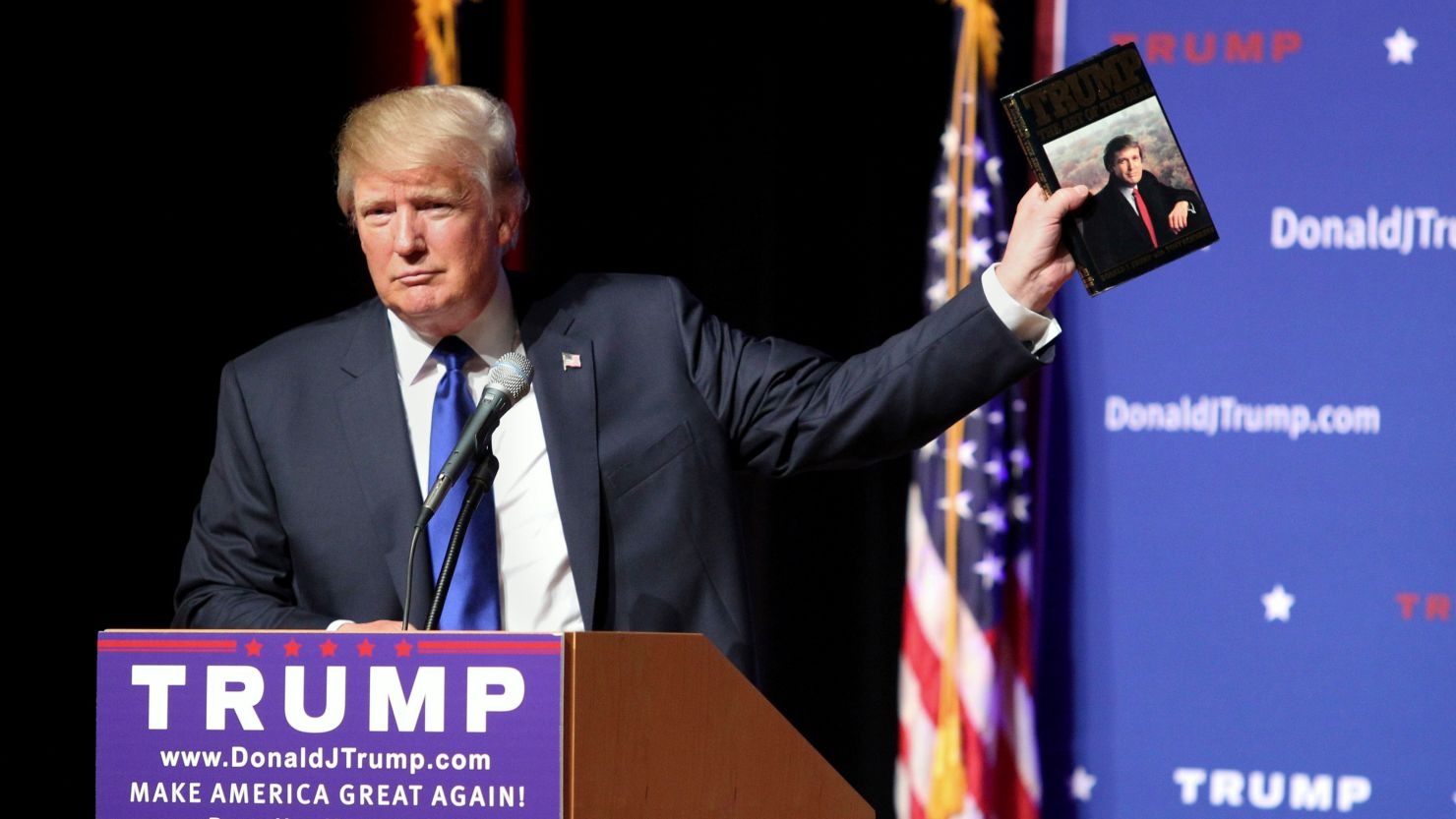 Donald Trump holds up a copy of his 1987 book, "The Art of the Deal" during a town hall event at Pinkerton Academy in Derry, New Hampshire, on August 19, 2015.