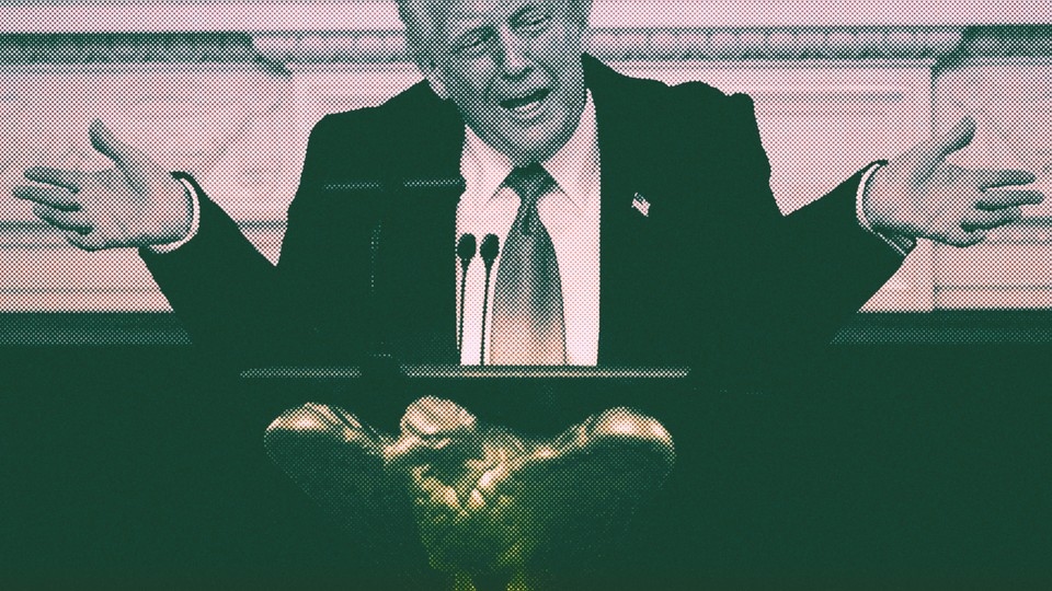 Donald Trump throws up his arms in front of a podium