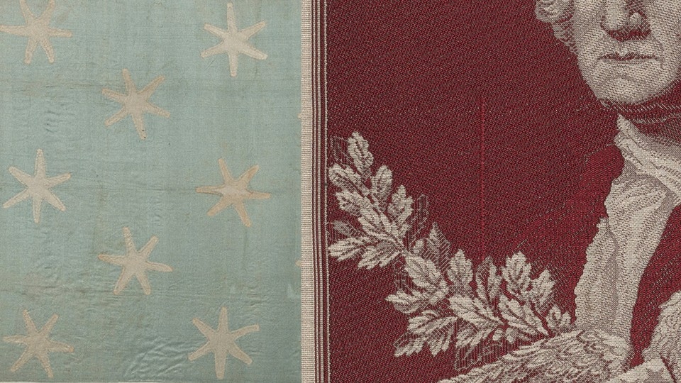 An embroidered portrait of George Washington next to the faded blue silk flag that indicated his presence on the Revolutionary War battlefield.