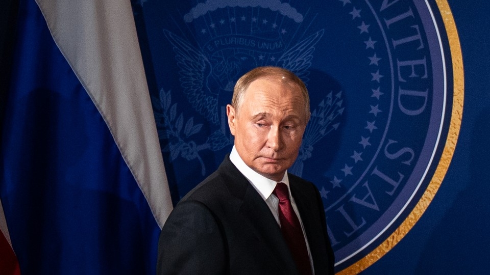 Photograph of Vladimir Putin in front of the seal of the United States