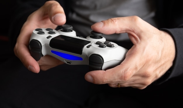 Premium Photo | Man holding white game controller - Seletive Focus