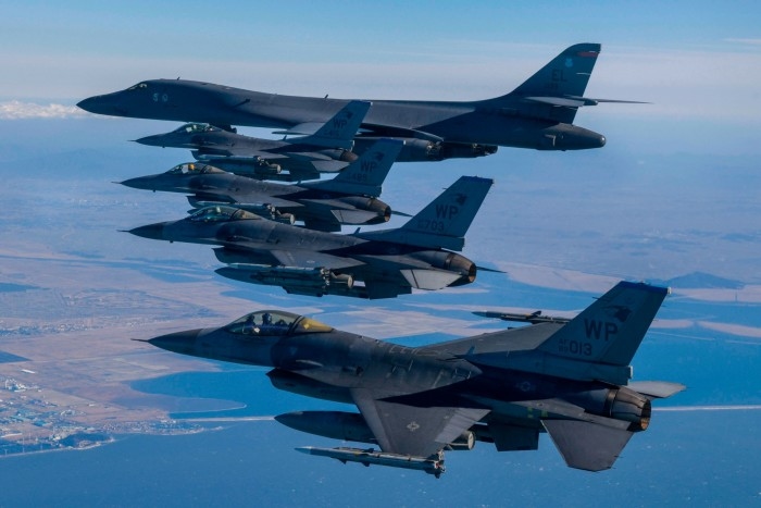 US Air Force B-1B bomber, (top), flies in formation with US Air Force F-16 fighter jets over the South Korea Peninsula during a joint air drill in February