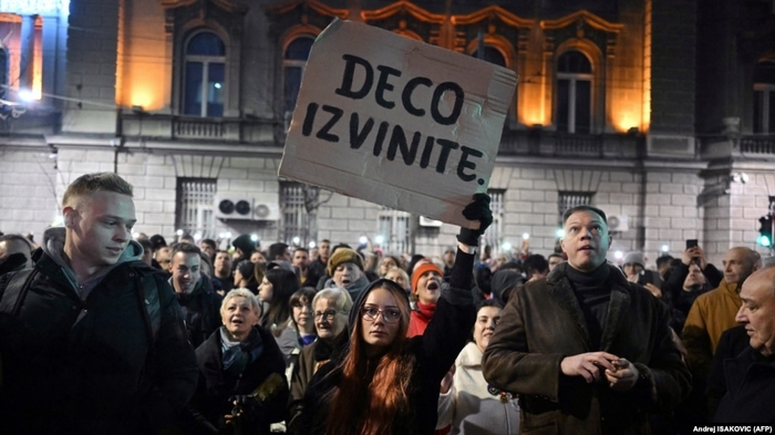 A woman holds a placard reading "Sorry children" as opposition supporters take part in a demonstration outside the Electoral Committee building in Belgrade on December 18.