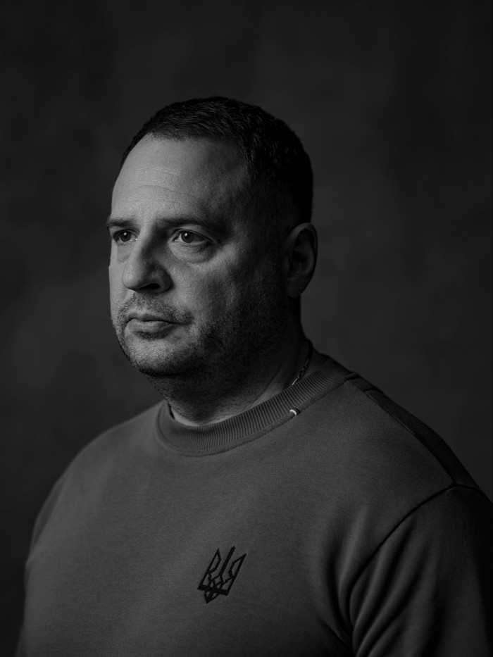 Black and white portrait of a man wearing a sweatshirt with a Ukrainian trident emblem