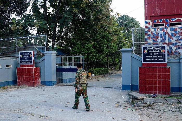 This photo taken on 9 November 2023 shows a fighter of the ethnic rebel group Ta'ang National Liberation Army (TNLA) walking past the police station in the town of Namhkam in northern Shan state. (Mai Nyi/AFP)