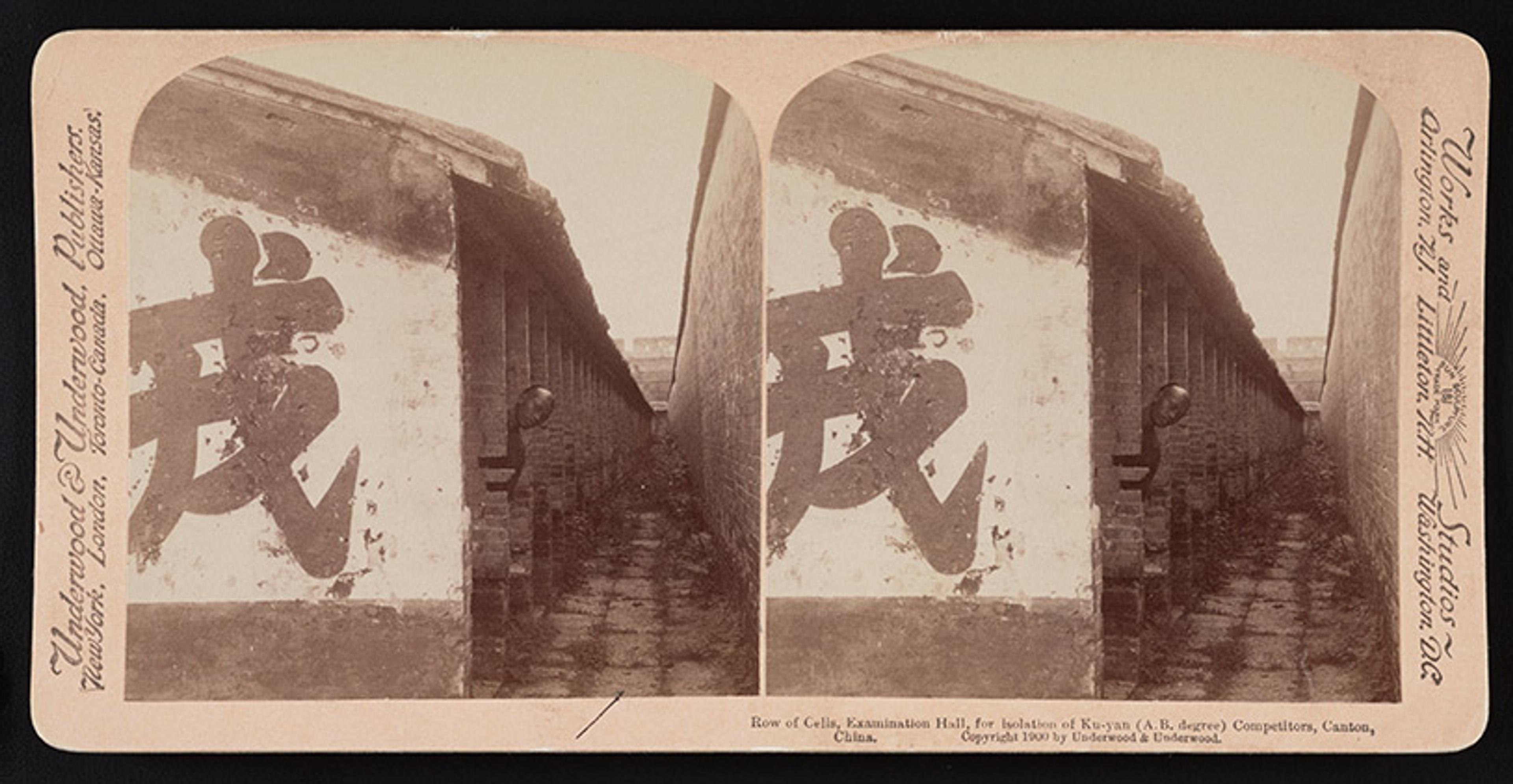 A man peers from a long line of cells constructed to ensure privacy during examination conditions. It is an old stereoscope pictur