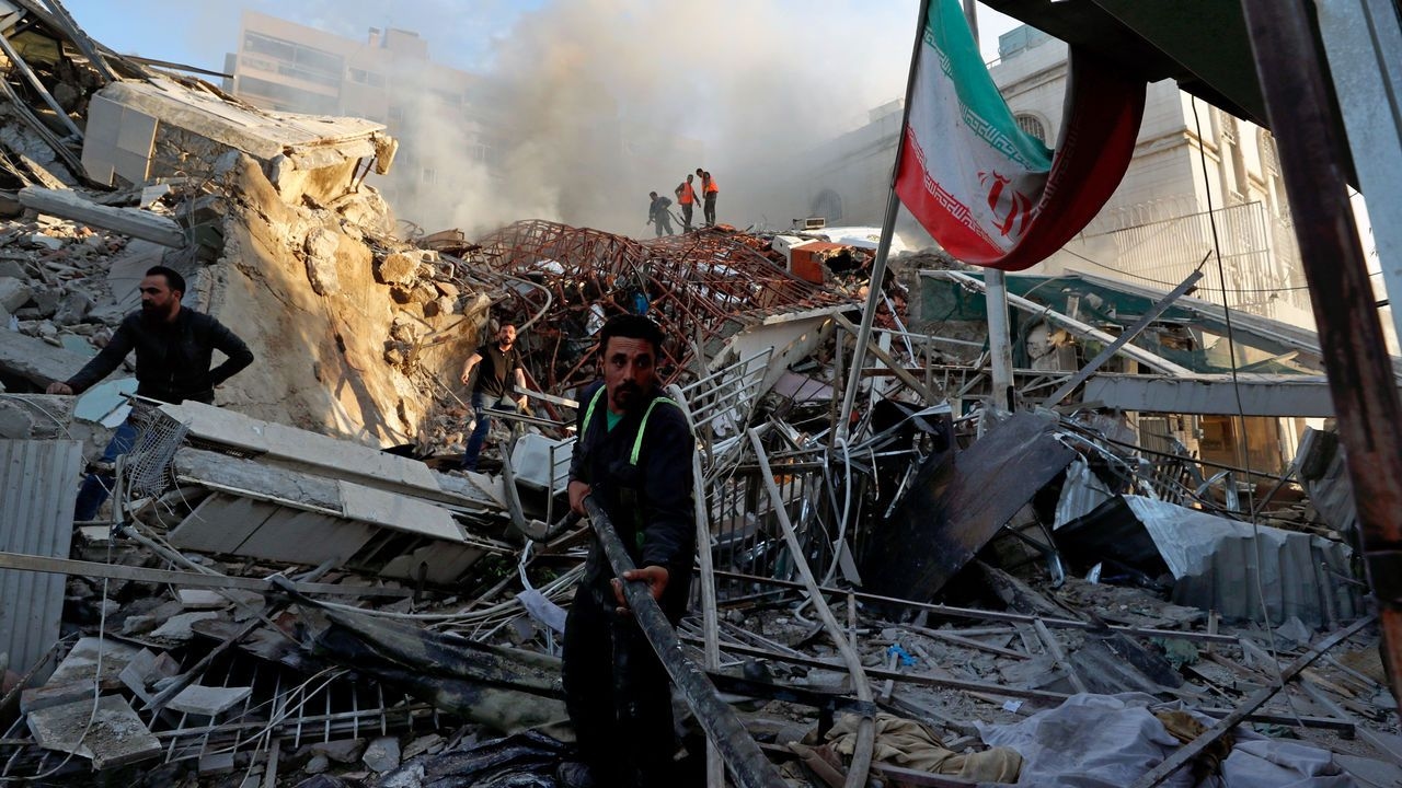 Emergency services work at a building hit by an air strike in Damascus, Syria, Monday, April 1, 2024.   An Israeli airst
