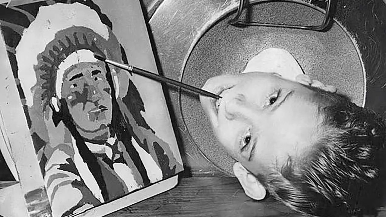 Paul Alexander as a young boy, painting with his mouth