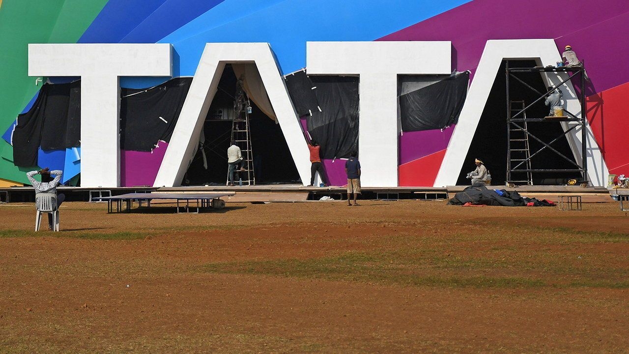 Workers are seen working near a Tata logo in Mumbai.