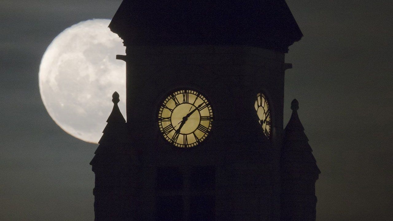 The moon rises behind the clock tower of the Wichita-Sedgwick County Historical Museum, Wichita, Kansas