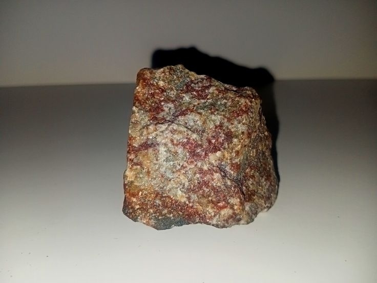 Альбітит з титанітом (сфеном). З альбітитами Жовторічанського родовища пов'язані поклади урану. На цьому ж фото ми бачимо червоні вкраплення титаніту (сфену)