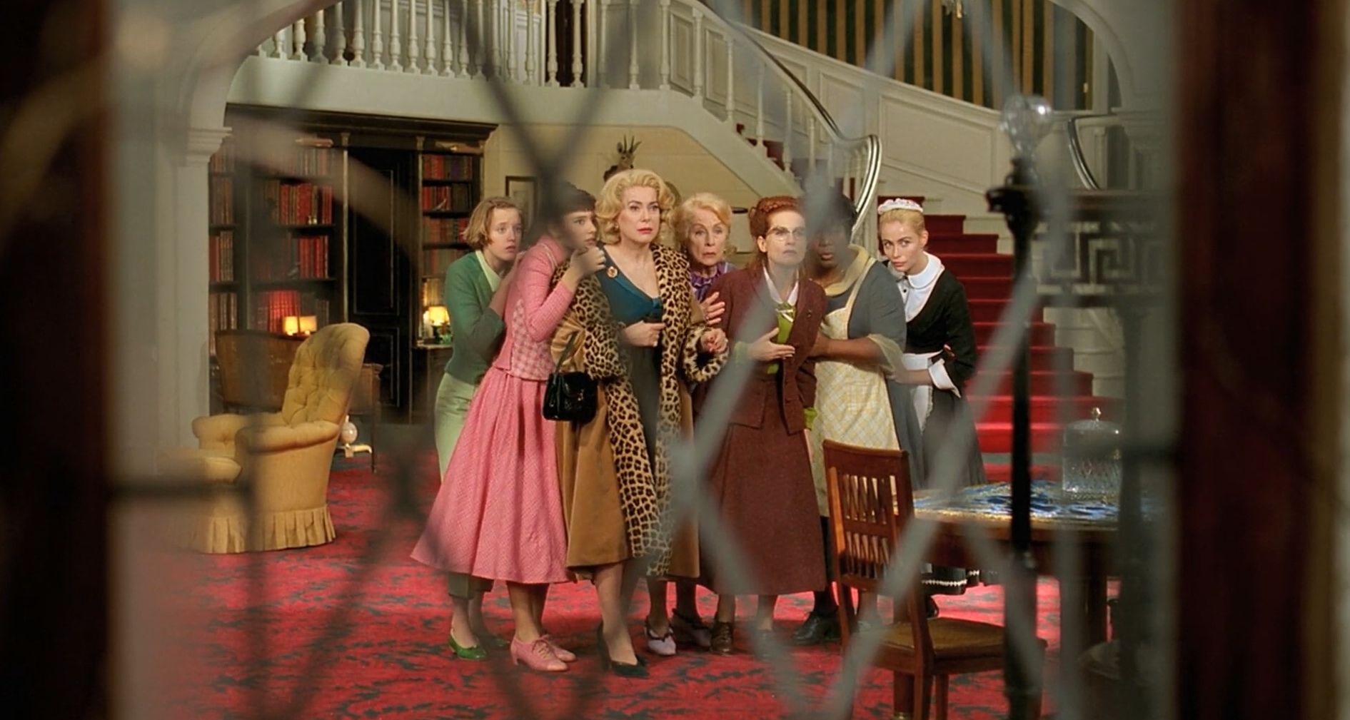 Театральність вельми очевидна насамперед у подібній згуртованости й майже типажній зовнішності. Але мені цей кадр нагадав дещо інше. У “Нишпорці” Манкевича теж є кадри, коли камера дивиться крізь вікно, і там середник був зроблений навмисно, аби персонажі були по центру кожної клітини, щораз були на видноті. Тут цього немає, і це — межа гарного та великого кіна.