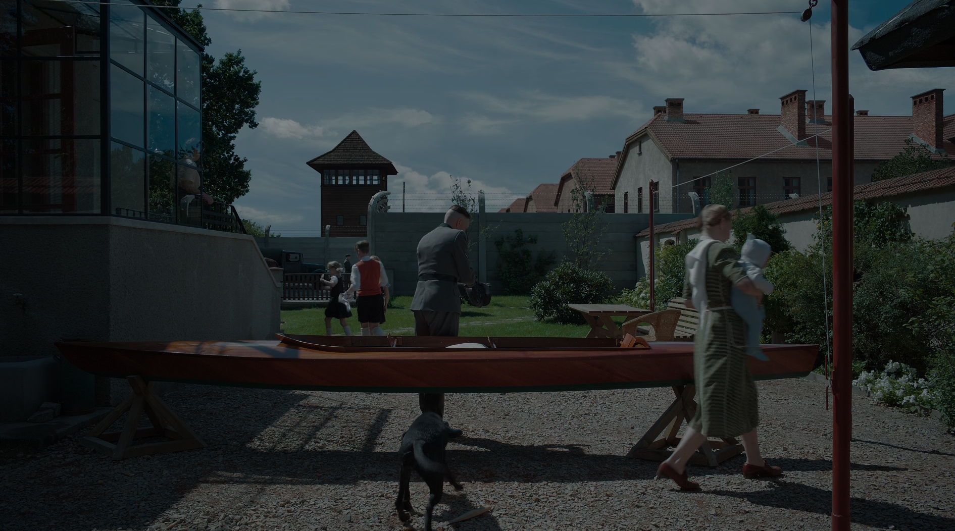 Перший кадр зіставлення приватного сімейного щастя родини Гессе на тлі Аушвіцу через дорогу. Фільм буквально створений заради цього одного кадру. Достобіса красного, заповненого по вінця, але щораз показувати те саме в різних форматах зрештою призводить до втрати ефекту, котрий мав цей перший кадр.