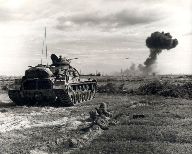 r/MilitaryPorn - An M48 Patton provides support to infantry as an F-4 Phantom II fighter-bomber makes a bomb run over the near horizon during Operation Junction City, South Vietnam, 1968. [1000x803]
