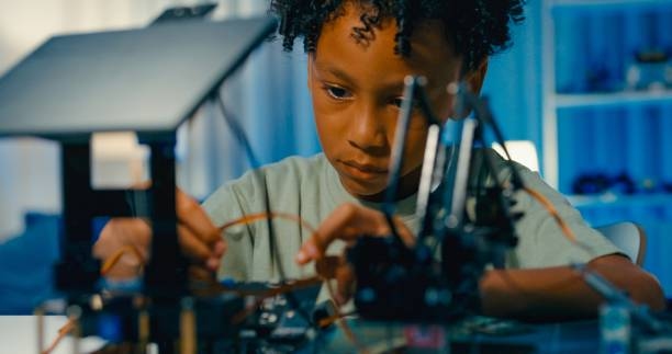 Closeup of young African-American boy carefully assembles robotic car, demonstrating skills in science and technology in home at night. STEM Education robotics courses online. Closeup of young African-American boy carefully assembles robotic car, demonstrating skills in science and technology in home at night. STEM Education robotics courses online concept. Empowering the Future Through Education & Innovation stock pictures, royalty-free photos & images