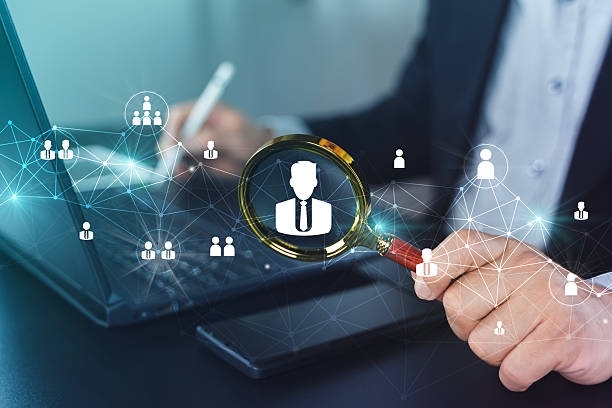 Customer Data Search and Recruitment Analytics with Magnifying Glass on Laptop Business professional using magnifying glass over user icon on laptop, showing network connections for HR recruitment, customer search, identity verification, and data security analytics. Database Validation stock pictures, royalty-free photos & images