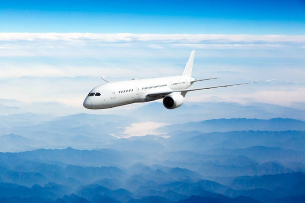 Passenger Aircraft In Flight The Plane Flies Over The Mountains Stock Photo  - Download Image Now - iStock