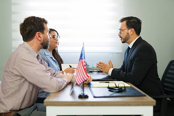 Couple discussing immigration legal advice with lawyer Serious applicants consulting with attorney about immigration law, receiving professional legal advice and guidance for their future  visa consultants stock pictures, royalty-free photos & images