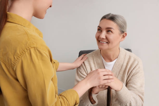 Caregiver and senior woman with walking cane sitting at home Caregiver and senior woman with walking cane sitting at home NDIS Support Coordination stock pictures, royalty-free photos & images