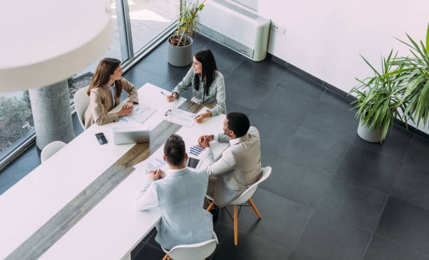 Business persons on meeting in the office. Above view of group of business persons in business meeting. Group of entrepreneurs on meeting in board room. Corporate business team on meeting in the office. Business Consulting Firms stock pictures, royalty-free photos & images