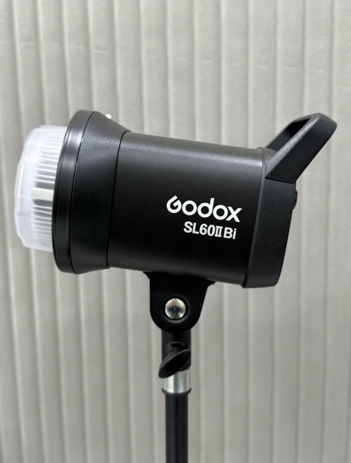 Студійний LED моноблок Godox SL60IIBi на легкій стійці на тлі акустичної рейкової стіни